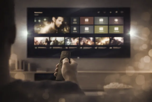 A hand on the remote, choosing a channel from the list