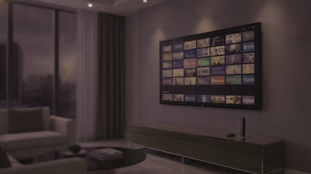 A living-room TV showing an IPTV channel guide with a streaming stick on the console